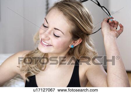 Woman taking off her glasses View Large Photo Image Stock Photo - Woman taking off her glasses. Fotosearch