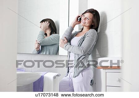 Woman talking on cell phone in bathroom View Large Photo Image Stock Photo - Woman talking on cell phone in bathroom. Fotosearch