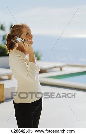 Woman talking on cell phone outdoors View Large Photo Image Stock Photography - Woman talking on cell phone outdoors. Fotosearch