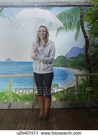 Woman under umbrella with beach backdrop View Large Photo Image Stock Image - Woman under umbrella with beach backdrop. Fotosearch