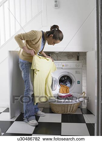 Woman unloading clothes from dryer View Large Photo Image Stock Image - Woman unloading clothes from dryer. Fotosearch
