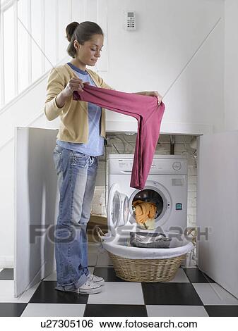 Woman unloading clothes from dryer View Large Photo Image Stock Photograph - Woman unloading clothes from dryer. Fotosearch