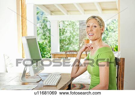 Stock Photo - Woman using computer at desk. Fotosearch