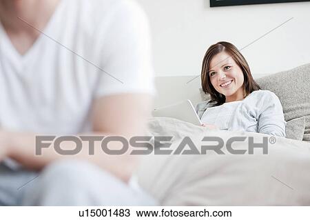 Stock Image - Woman using laptop in bed. Fotosearch
