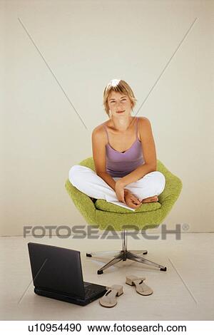 Woman using laptop in modern chair View Large Photo Image Stock Image - Woman using laptop in modern chair. Fotosearch