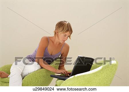 Picture - Woman using laptop in modern chairs. Fotosearch