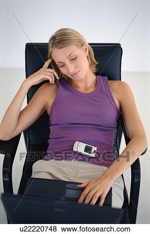 Stock Photo - Woman using laptop in office chair. Fotosearch
