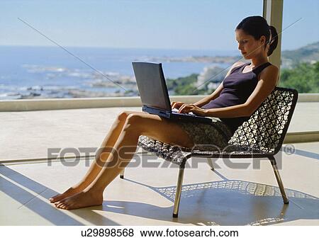 Stock Photo - Woman using laptop on roof. Fotosearch