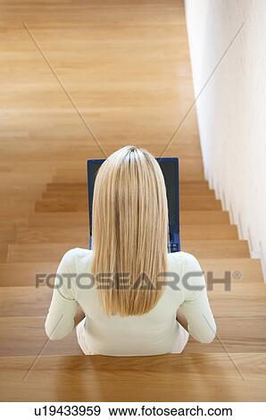 Stock Photo - Woman using laptop on stairs. Fotosearch