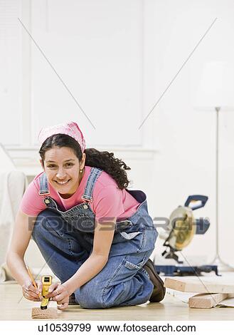 Stock Photo - Woman using power tools at home. Fotosearch