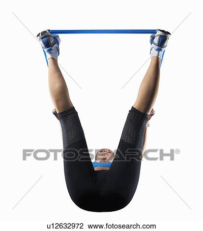 Stock Image - Woman using resistance band. Fotosearch