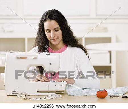 Woman using sewing machine at home View Large Photo Image Stock Photograph - Woman using sewing machine at home. Fotosearch