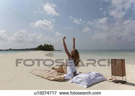 Woman waking up in bed on beach View Large Photo Image Stock Photo - Woman waking up in bed on beach. Fotosearch