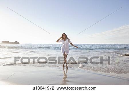 Woman walking in surf on beach View Large Photo Image Stock Image - Woman walking in surf on beach. Fotosearch