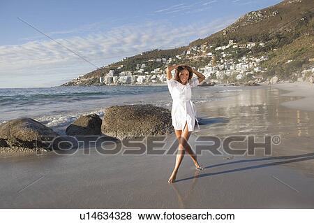 Stock Photo - Woman walking on beach. Fotosearch