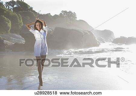Stock Photo - Woman walking on beach. Fotosearch