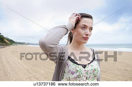 Stock Photograph - Woman walking on beach. Fotosearch