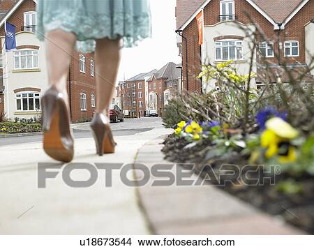 Woman walking on suburban street View Large Photo Image Picture - Woman walking on suburban street. Fotosearch