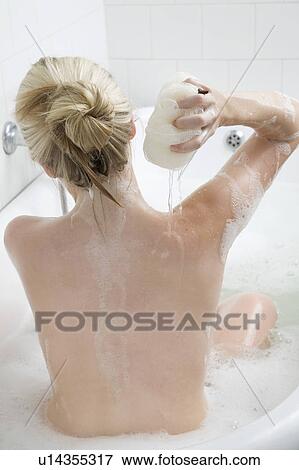 Stock Photo - Woman washing in bubble bath. Fotosearch