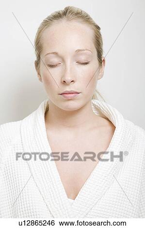 Stock Photograph - Woman wearing bathrobe with eyes closed. Fotosearch