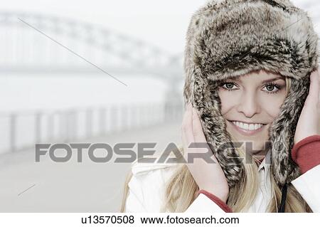 Woman wearing fur hat by urban bridge View Large Photo Image Stock Photo - Woman wearing fur hat by urban bridge. Fotosearch