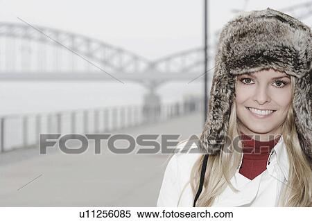 Woman wearing fur hat by urban bridge View Large Photo Image Stock Photography - Woman wearing fur hat by urban bridge. Fotosearch
