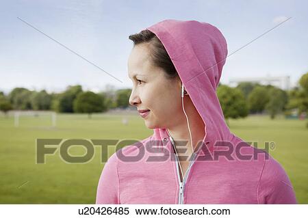 Woman wearing headphones in park View Large Photo Image Stock Photography - Woman wearing headphones in park. Fotosearch