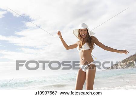 Woman wearing sunhat and bikini on beach View Large Photo Image Stock Photo - Woman wearing sunhat and bikini on beach. Fotosearch