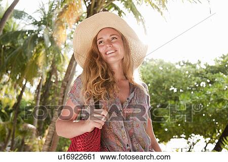 Woman wearing sunhat in tropical resort View Large Photo Image Stock Image - Woman wearing sunhat in tropical resort. Fotosearch