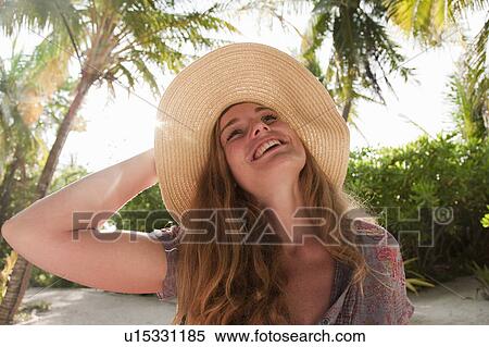 Woman wearing sunhat in tropical resort View Large Photo Image Stock Photography - Woman wearing sunhat in tropical resort. Fotosearch