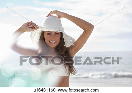 Woman wearing sunhat on beach View Large Photo Image Stock Image - Woman wearing sunhat on beach. Fotosearch
