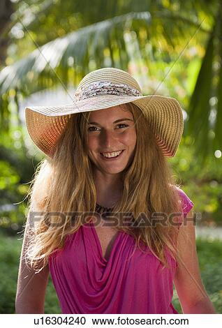 Stock Image - Woman wearing sunhat outdoors. Fotosearch