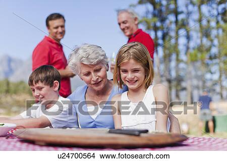 Woman with grandchildren at picnic table View Large Photo Image Picture - Woman with grandchildren at picnic table. Fotosearch