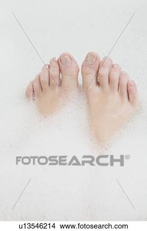 Picture - Woman’s feet in bubble bath. Fotosearch
