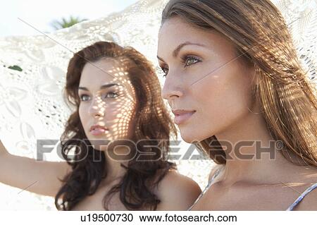 Women holding blanket over them View Large Photo Image Stock Image - Women holding blanket over them. Fotosearch