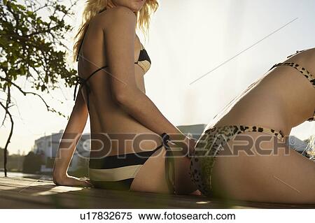 Women in bikinis sitting on deck View Large Photo Image Stock Photography - Women in bikinis sitting on deck. Fotosearch