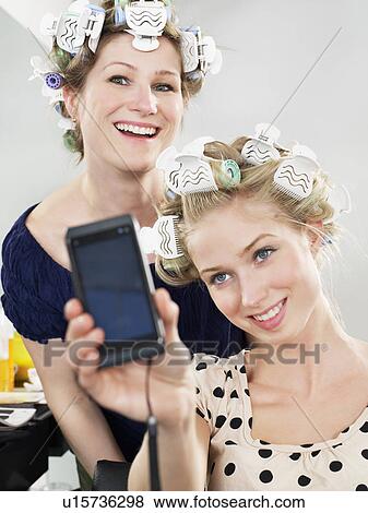Women photographing themselves in salon View Large Photo Image Stock Photo - Women photographing themselves in salon. Fotosearch