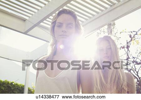 Stock Photo - Women standing together under canopy. Fotosearch