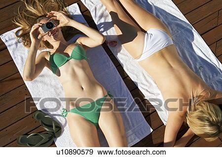 Women sunbathing and taking pictures View Large Photo Image Stock Photo - Women sunbathing and taking pictures. Fotosearch