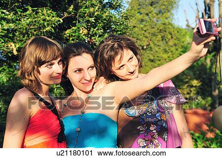 Stock Image - Women taking a picture of themselves. Fotosearch