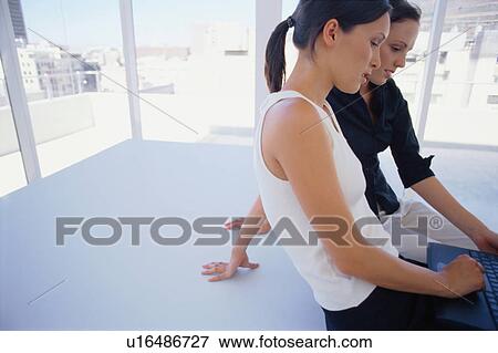 Women using laptop together View Large Photo Image Stock Photo - Women using laptop together. Fotosearch