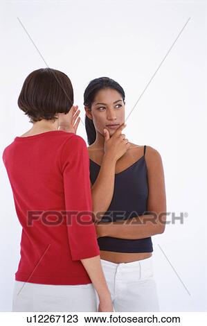 Stock Image - Women whispering to each other. Fotosearch