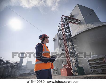Stock Photo - Worker at biomass storage facility. Fotosearch