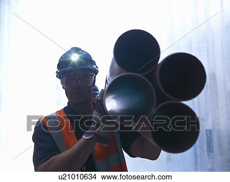 Picture - Worker carrying pipes. Fotosearch