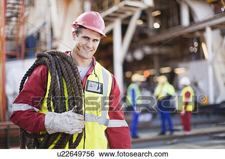 Worker carrying rope on oil rig View Large Photo Image Stock Photograph - Worker carrying rope on oil rig. Fotosearch