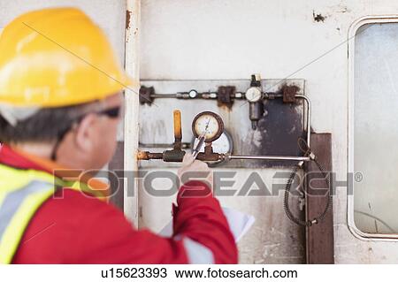 Worker checking gauge on oil rig View Large Photo Image Stock Image - Worker checking gauge on oil rig. Fotosearch