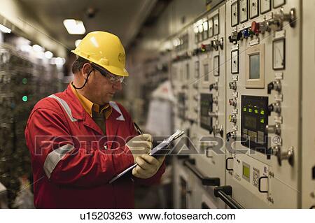 Worker checking machinery View Large Photo Image Stock Image - Worker checking machinery. Fotosearch