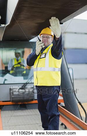 Worker directing machinery on site View Large Photo Image Picture - Worker directing machinery on site. Fotosearch