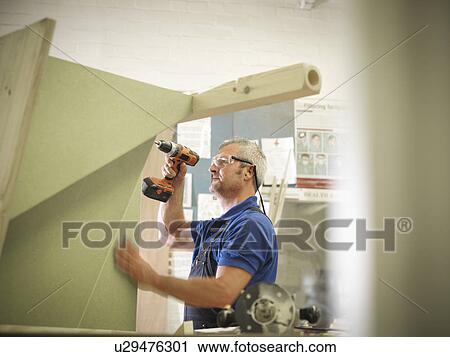 Worker drilling wood in joinery View Large Photo Image Stock Image - Worker drilling wood in joinery. Fotosearch