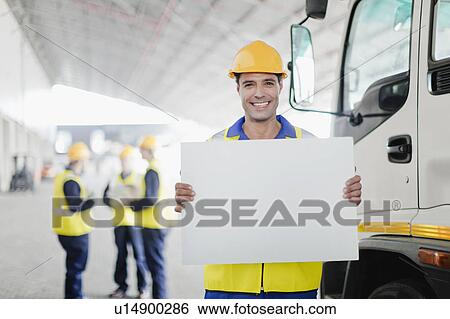 Worker holding blank card by truck View Large Photo Image Stock Photograph - Worker holding blank card by truck. Fotosearch